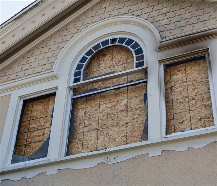 Windows boarded up in a home with fire damage.